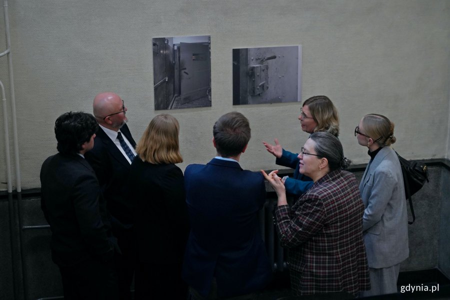 Goście zaproszeni na inaugurację wystawy w sądzie przyglądający się ekspozycji 