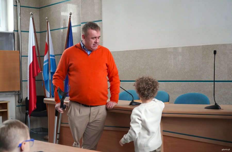 Mężczyna na pomarańczowym swetrze i mały chłopiec