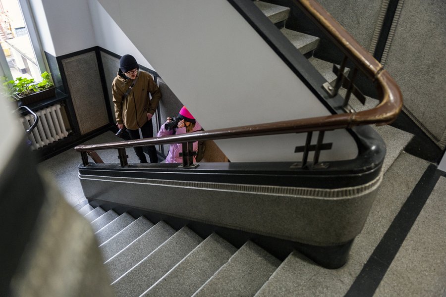 Dwie osoby na schodach klatki schodowej robi zdjęcia.