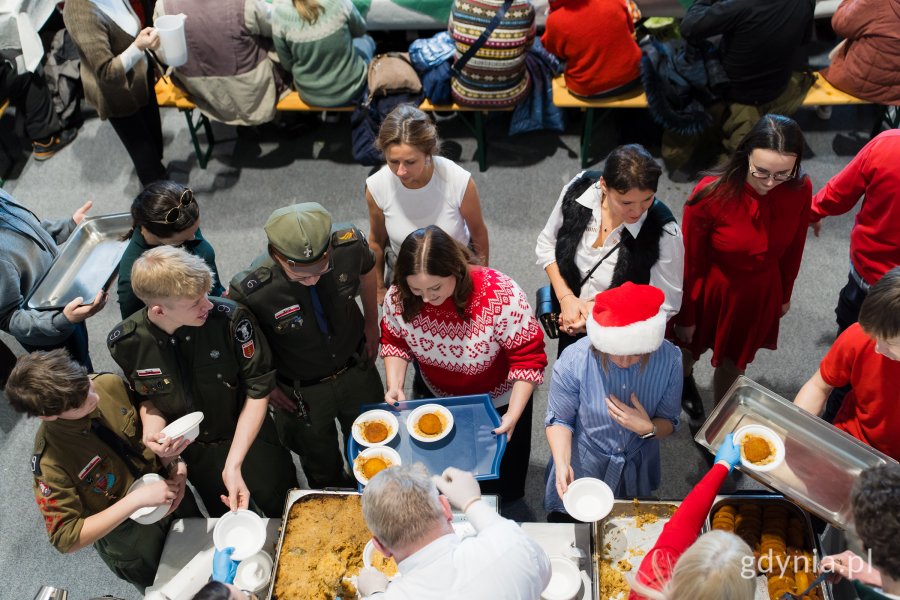 Wolontariusze oraz prezydent Gdyni Aleksandra Kosiorek pomagający w organizacji wigilii dla samotnych i potrzebujących