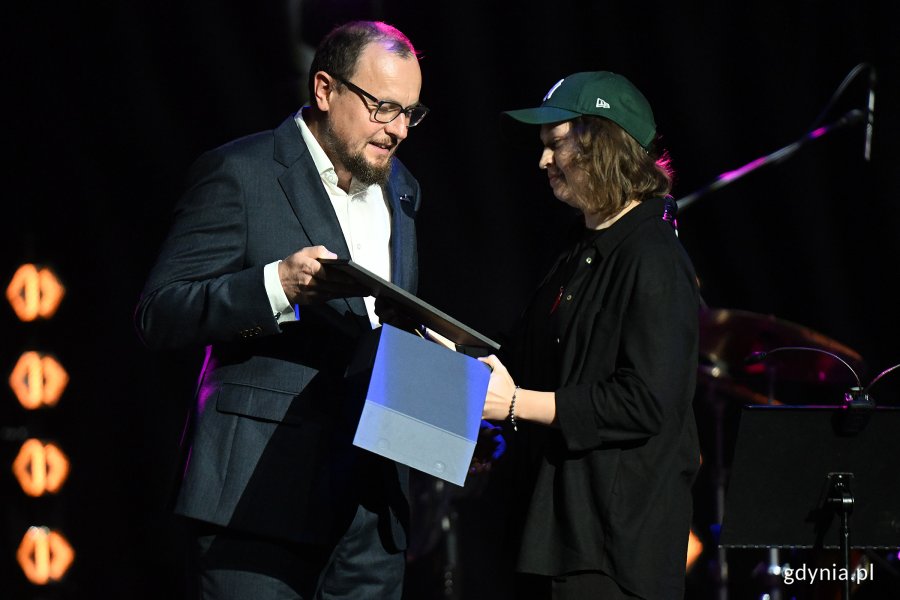 Dyrektor zarządzający ds. kultury i aktywności mieszkańców Mariusz Bzdęga wręcza nagrodę Hani Derej 
