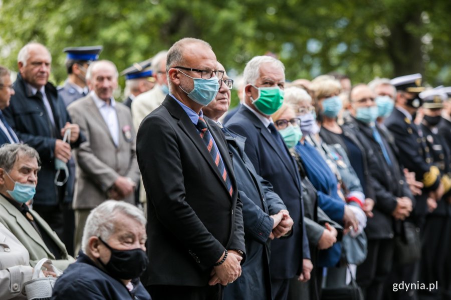Uczestnicy gdyńskich obchodów Dnia Sybiraka stoją w rzędzie. Na pierwszym planie, w niebieskiej maseczce, wiceprezydent Gdyni Michał Guć. Obok, w zielonej maseczce, wicewojewoda pomorski Mariusz Łuczyk // fot. Karol Stańczak
