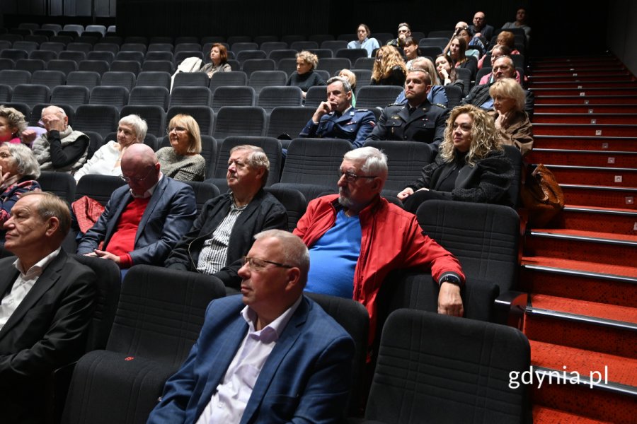Elegancko ubrane osoby siedzące na sali kinowej