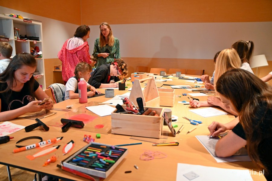 Uczestnicy zajęć w świetlicy Muzeum Miasta Gdyni siedzą pzry stole i tworzą swoje prace // fot. Magdalena Czernek