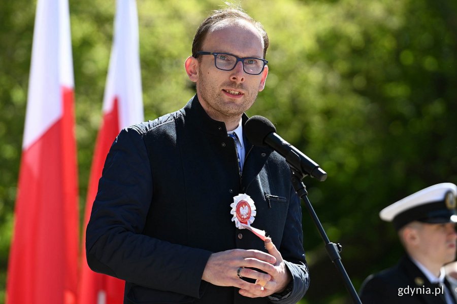 Jakub Ubych - wiceprzewodniczący Rady Miasta Gdyni podczas uroczystości z okazji Narodowego Święta Konstytucji 3 Maja. W tle biało-czerwone flagi // fot. Michał Puszczewicz