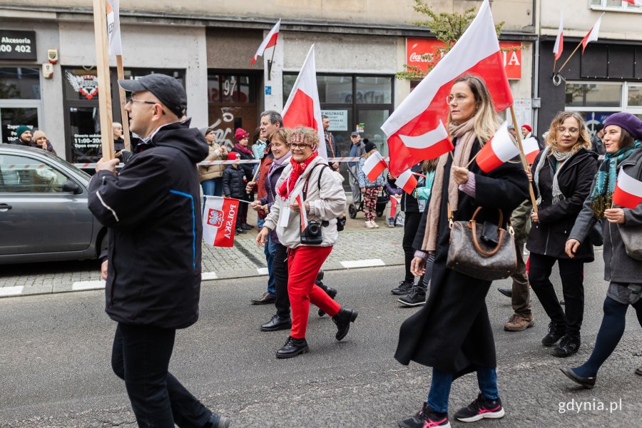 Uczestnicy parady z okazji Narodowego Święta Niepodległości z biało-czerwonymi flagami w rękach // fot. Karol Stańczak