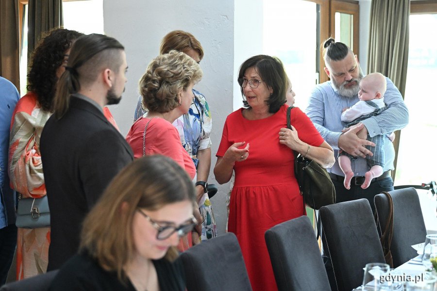 Grupa os&oacute;b, mężczyzna z niemowlakiem 