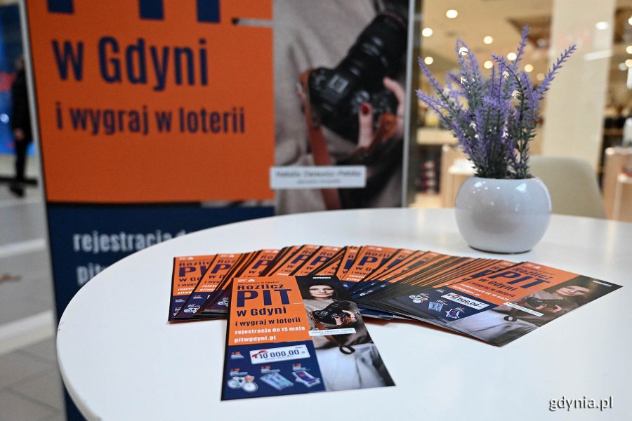 Ulotki dotyczące loterii „Rozlicz PIT w Gdyni” leżące na stoliku 