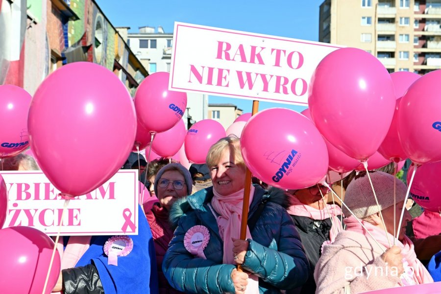 Uczestniczki Marszu Różowej Wstążki trzymające różowe balony i tabliczki z hasłami: „Rak to nie wyrok” i „Wybieram życie”