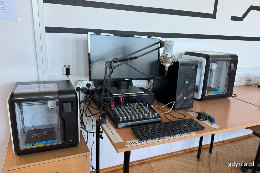 stoły na których stoją od lewej, drukarka 3D, radiowęzeł i dalej kolejna drukarka 3D