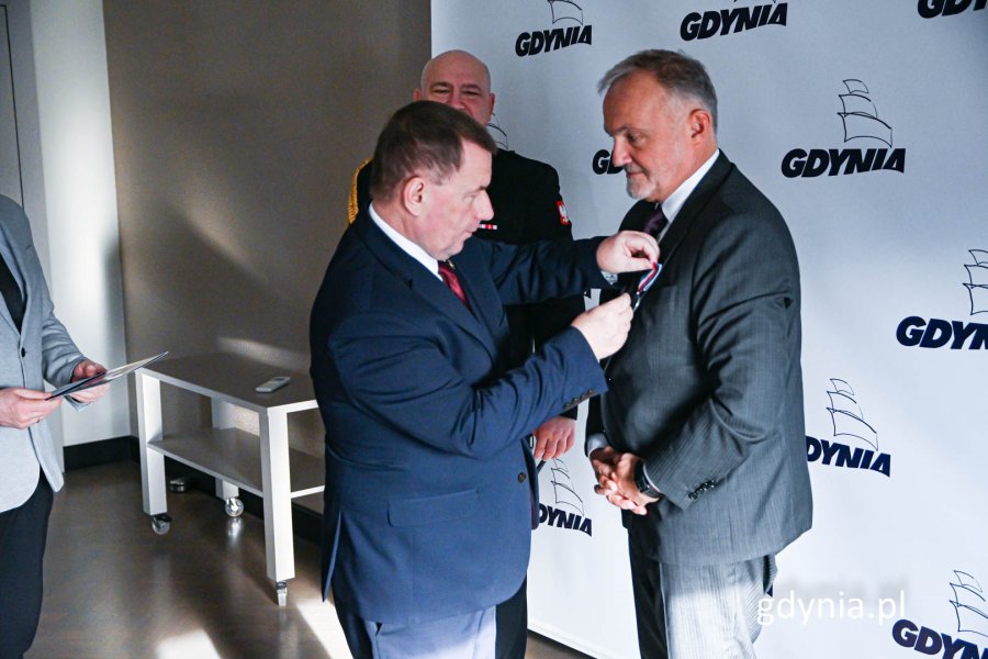 Prezes stowarzyszenia "Pamięć" przypina medal prezydentowi miasta Gdyni (fot. Michał Sałata)
