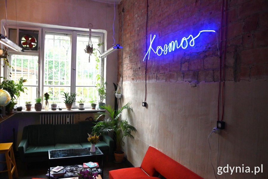 Wnętrze kawiarni „Kosmos” i na ścianie neon z nazwą kosmos
