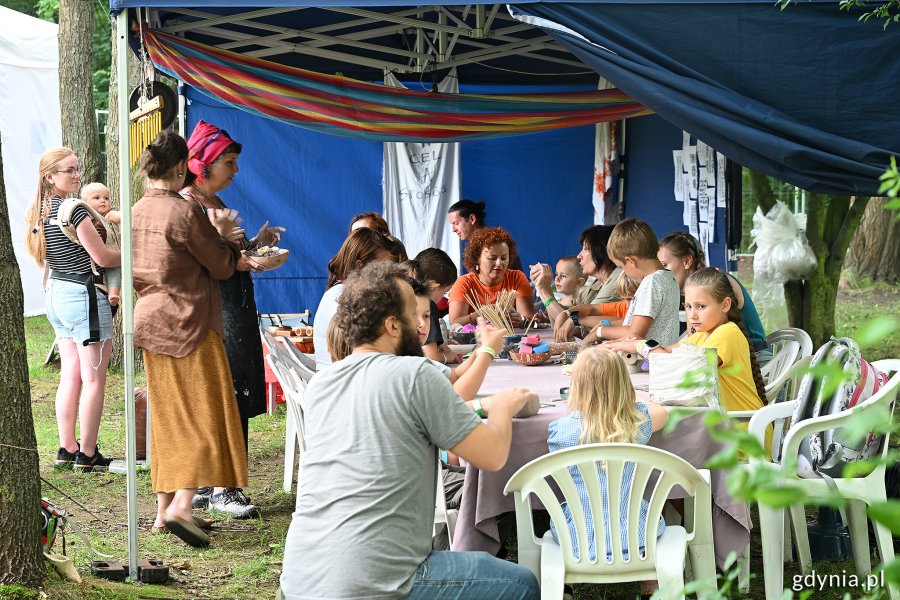 Dzieci i dorośli siedzący przy stole podczas warsztatów w jednej z festiwalowych stref