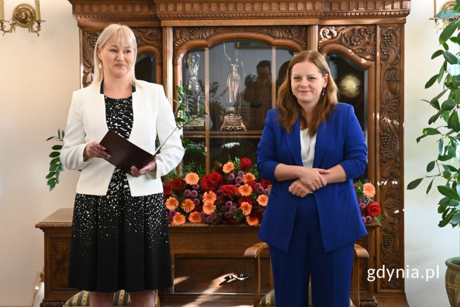 Dwie elegancko ubrane kobiety stojące w eleganckiej sali