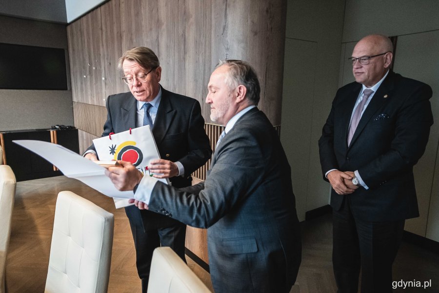 Prezydent Gdyni Wojciech Szczurek i JE Ramiro Fernández - ambasador Królestwa Hiszpanii w Polsce przekazują sobie okolicznościowe upominki. Z tyłu: Maciej Dobrzyniecki, konsul honorowy Hiszpanii w Gdańsku podczas spotkania w Urzędzie Miasta Gdyni // fot. Kamil Złoch