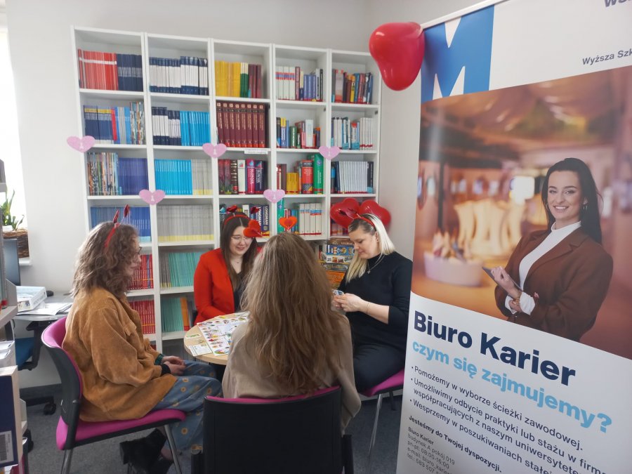 cztery panie grające w grę planszową w bibliotece