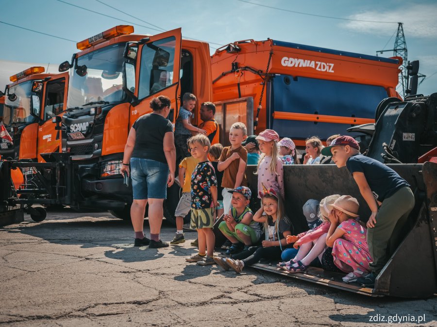 Wizyta przedszkolaków w bazie LIZUD, dzieci na tle pojazdów do oczyszczania miasta