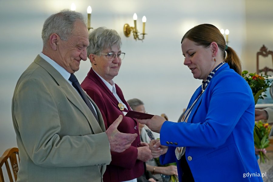 Prezydent Aleksandra Kosiorek wręcza medal jubilatom 