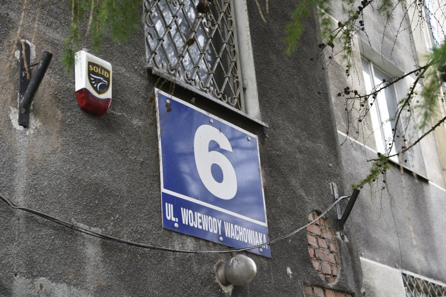 Fragment budynku z tabliczką adresową przy ulicy Wachowiaka 6