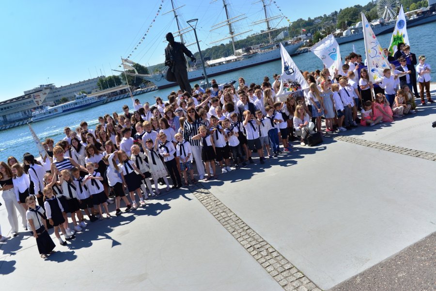 Grupa uczniów pozująca pod pomnikiem Tadeusza Wendy
