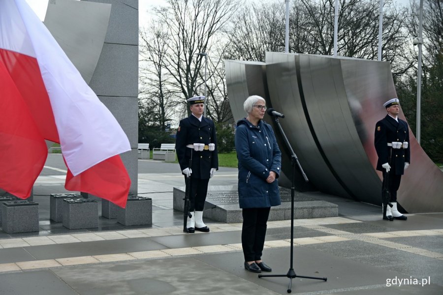 Joanna Zielińska - przewodnicząca Rady Miasta Gdyni przemawiająca podczas obchodów 79. rocznicy zakończenia walk o Gdynię. W tle: posterunek honorowy przy pomniku Polski Morskiej