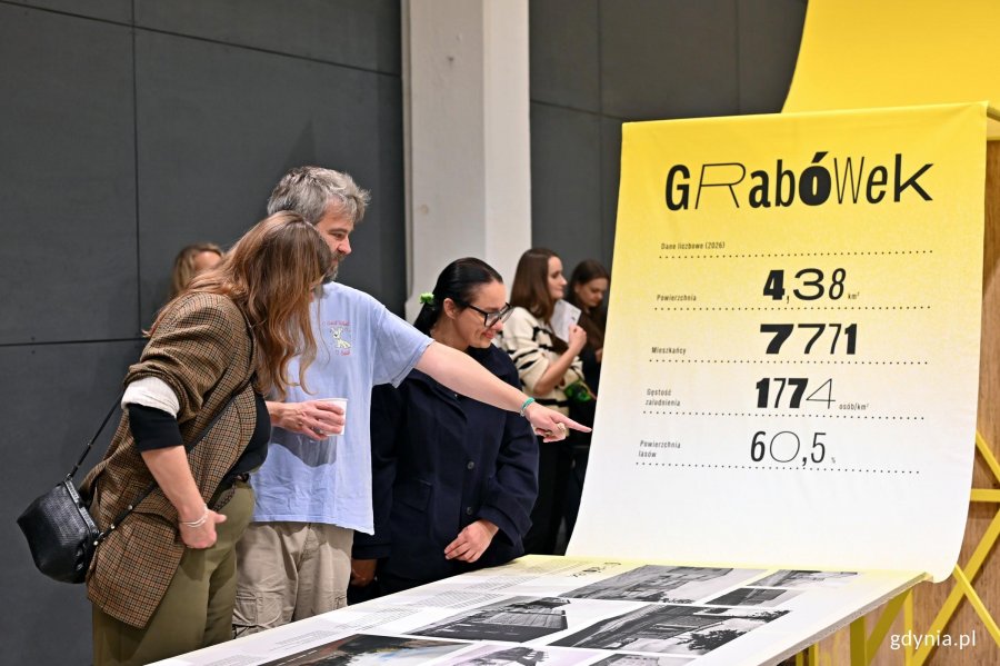 Pisarz Zygmunt Miłoszewski, dyrektorka Teatru Miejskiego w Gdyni Marta Miłoszewska oraz dyrektorka Gdyńskiego Centrum Kultury Katarzyna Korzeniewska oglądający wystawę &bdquo;Gen 100 &ndash; gdyński kod wsp&oacute;lnoty&rdquo; 