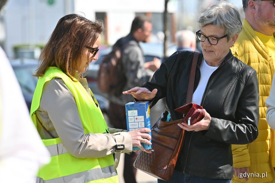 Kwestująca radna Anna Szpajer i kobieta wrzucająca datek do puszki