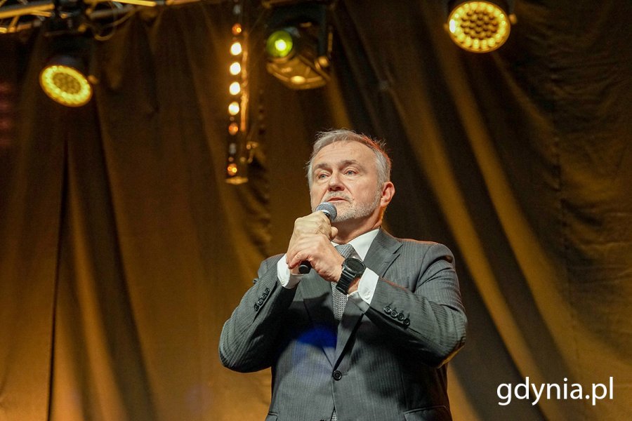 Mężczyzna przemawia na scenie.