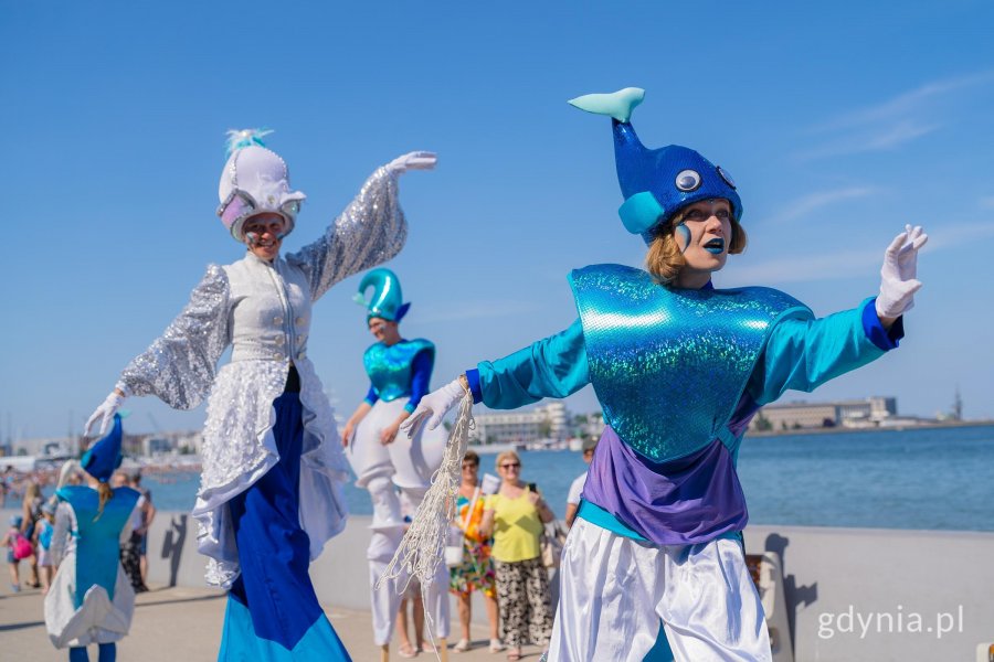 Artyści na szczudłach na tle plaży w Gdyni