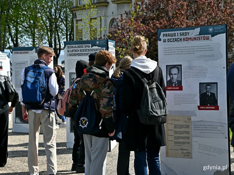 Uczniowie przyglądający się wystawie „«Sąd nie powinien wyrzec się stosowania terroru...». Sąd Marynarki Wojennej 1945–1990” na placu Wolnej Ukrainy 