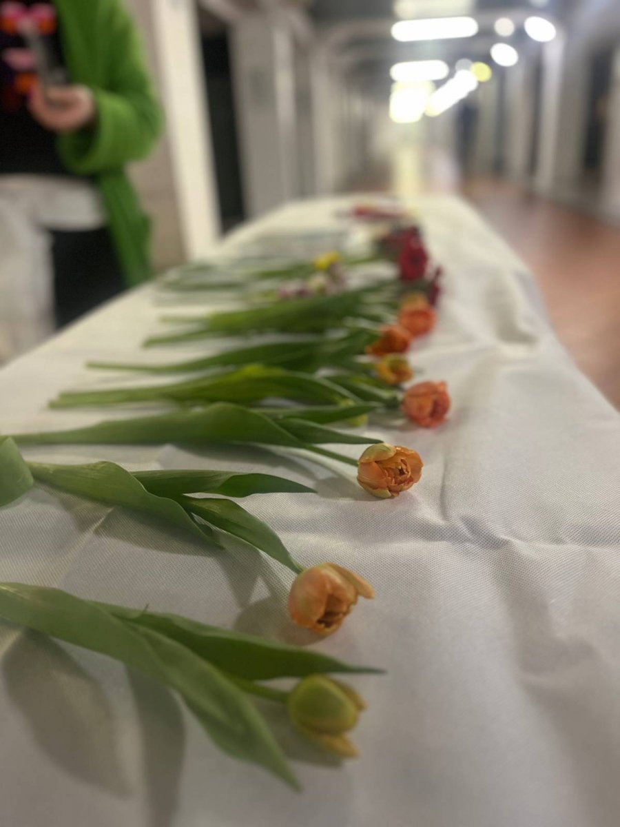 Kwiaty ułożone w rzędzie na białym obrusie