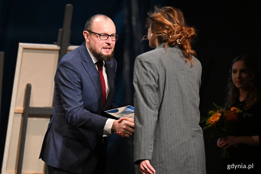 Mariusz Bzdęga - dyrektor zarządzający ds. kultury i aktywności mieszkańców wręcza Nagrodę Prezydent Miasta Gdyni z okazji Międzynarodowego Dnia Teatru aktorce Julii Pawlak z Teatru Czwarte Miasto 