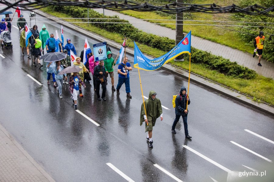 Uczestnicy 37. Gdyńskiej Pieszej Pielgrzymki na Jasną Górę w drodze. Jako pierwsi idą uczestnicy trzymający baner z napisem "Uśmiechnij się, jesteśmy z Gdyni" // fot. Karol Stańczak
