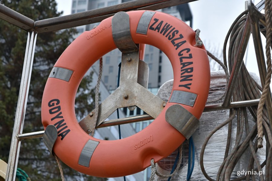 Pomarańczowe koło ratunkowe z czarnymi napisami: „Zawiszy Czarnym” oraz Gdynia // fot. Magdalena Czernek