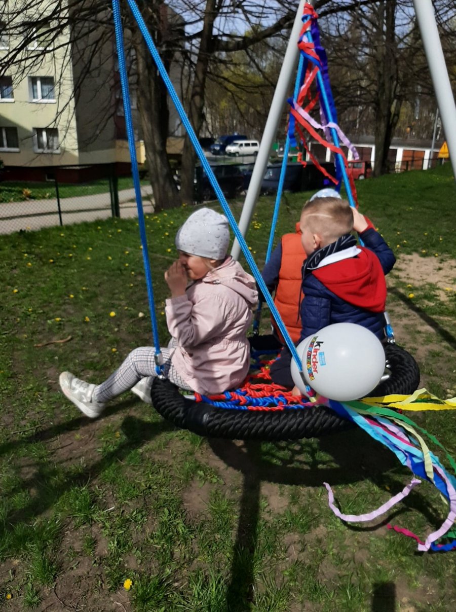 Trójka dzieci buja się w bocianim gnieździe, czyli w huśtawce, której spore okrągłe siedzisko wykonane z mocnych lin pomieści nie tylko najmłodszych.