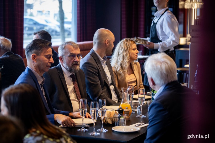 Ludzie rozmawiają przy stole w restauracji.