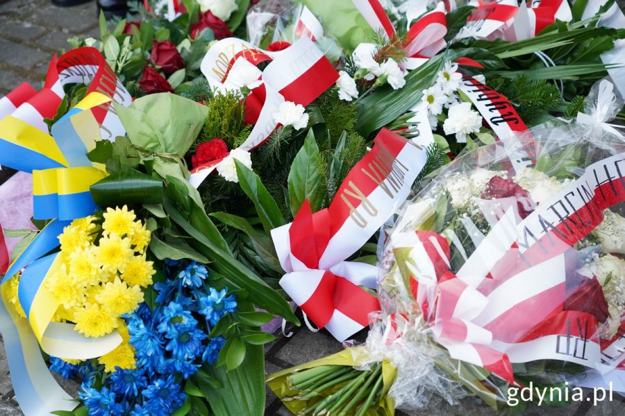 Wiązanki kwiatów pod tablicą przy Bazylice Morskiej