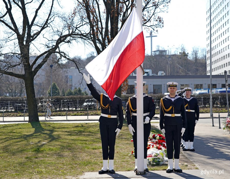 Poczet sztandarowy wciągający biało-czerwoną flagę na maszt podczas uroczystości z okazji 80. rocznicy zakończenia walk o Gdynię 