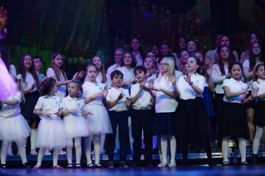 Dzieci w białych strojach na scenie