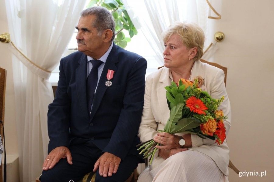 Para, mężczyzna z medalem, kobieta z bukietem kwiat&oacute;w