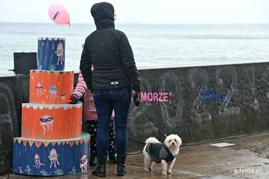 Uczestnicy karnawałowej zabawy na bulwarze Nadmorskim przy jednym z kolorowych tortów. Na murze widać napis: "Morze" // fot. Magdalena Czernek