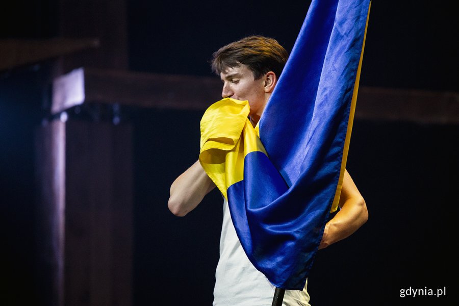 Jeden z tancerzy z zespołu tanecznego „Sonechko” całuje ukraińską flagę // fot. Przemysław Kozłowski