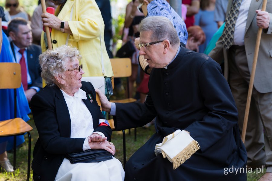 Meżczyzna w sutannie rozmawia z kobietą