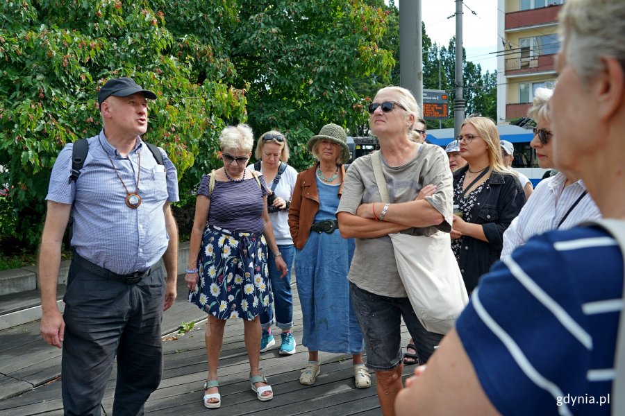 Przewodnik Jarosław Kaczmarczyk wraz z uczestnikami spaceru architektonicznego szlakiem modernizmu przed InfoBoksem 