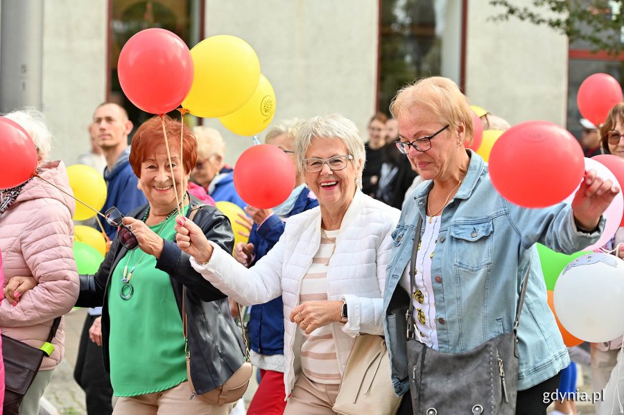 Uczestnicy przemarszu w ramach V Pomorskiego Dnia Seniora. W rękach trzymają kolorowe balony