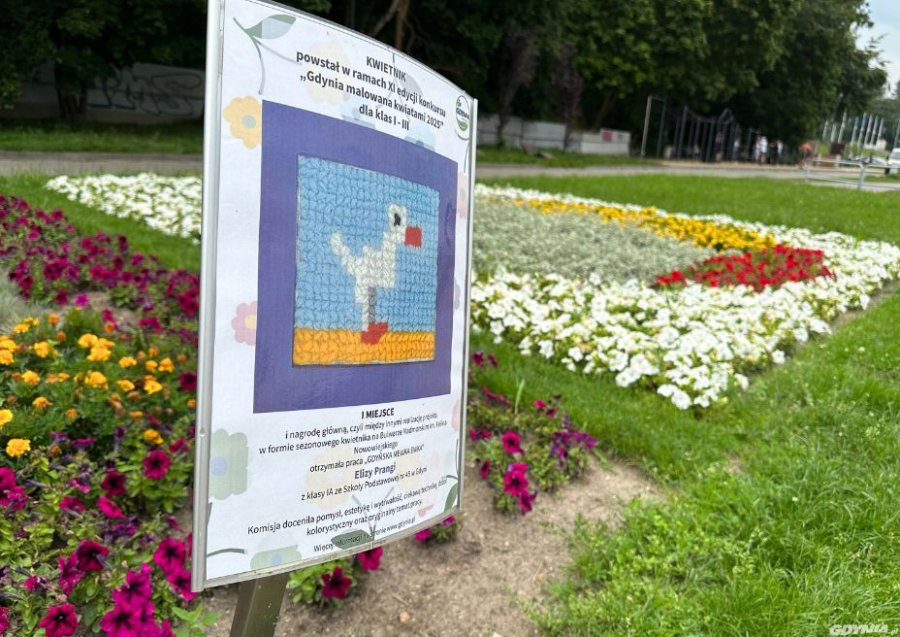 na zdjęciu tabliczka i kolorowa rabatka