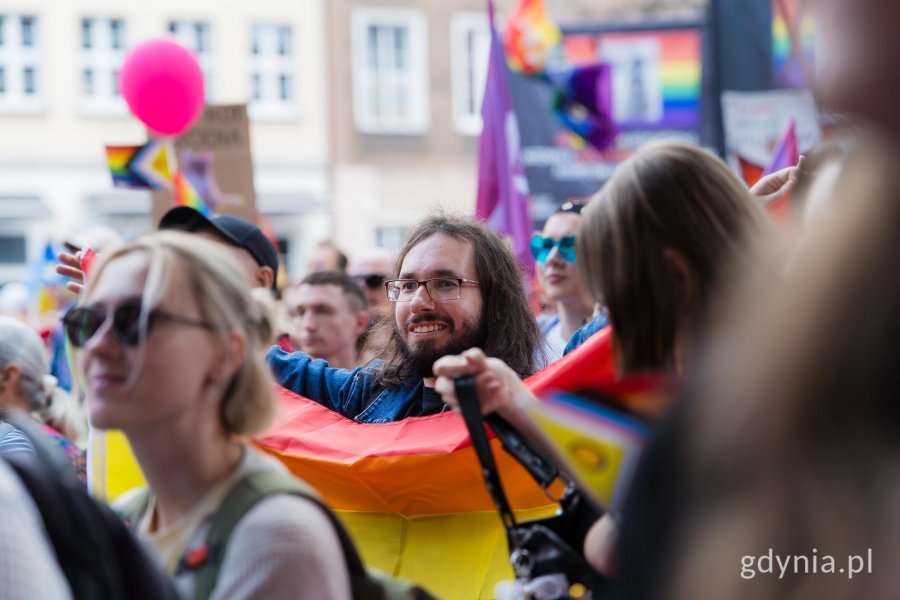 Uczestnicy 11. Tr&oacute;jmiejskiego Marszu R&oacute;wności z flagami w rękach