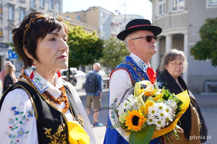 Odświętnie ubrani ludzie z kwiatami