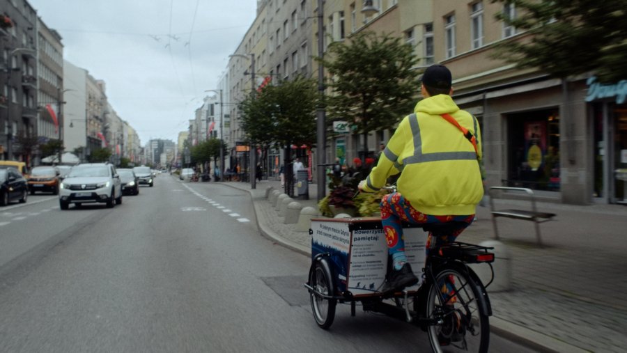 Mężczyzna jedzie rowerem cargo po ul. Świętojańskiej