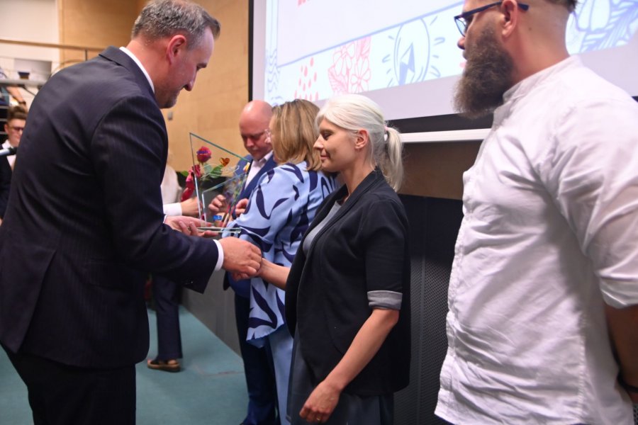 Mężczyzna wręcza kobiecie nagrodę 